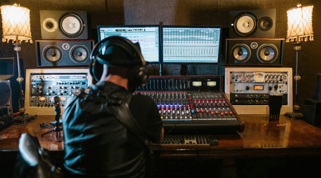Sound engineer mixing audio on console in recording studio.